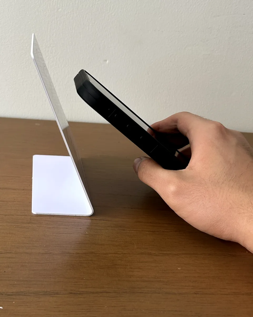 Una mano acerca el celular al soporte NFC